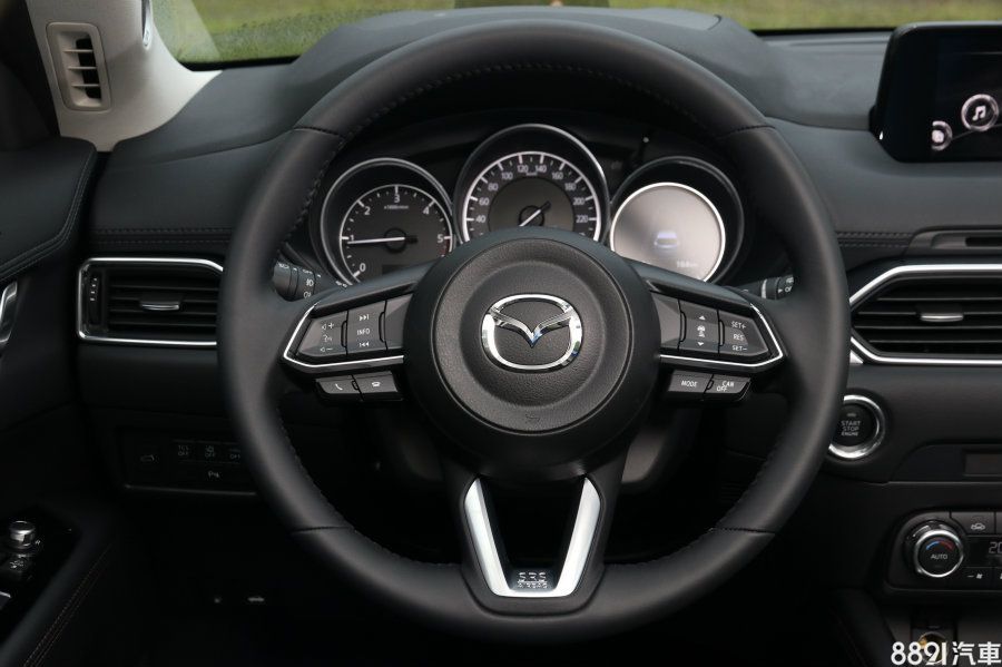 新式樣三輻式多功能方向盤與CX-9同款，左側為音量、藍芽、INFO鍵用以調整儀錶右側的MID顯示幕（Sky-G 2WD頂級型以上標配），右側則可設定定速巡航。