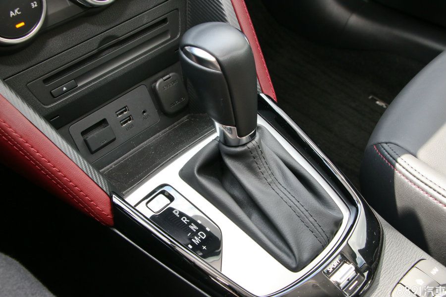 活潑配色一路延用至下方的排檔處，仔細一看，紅色皮革內部還帶有類碳纖維的紋路，加分不少，不過若能同樣採用電子手剎車，相信質感會大幅提升。